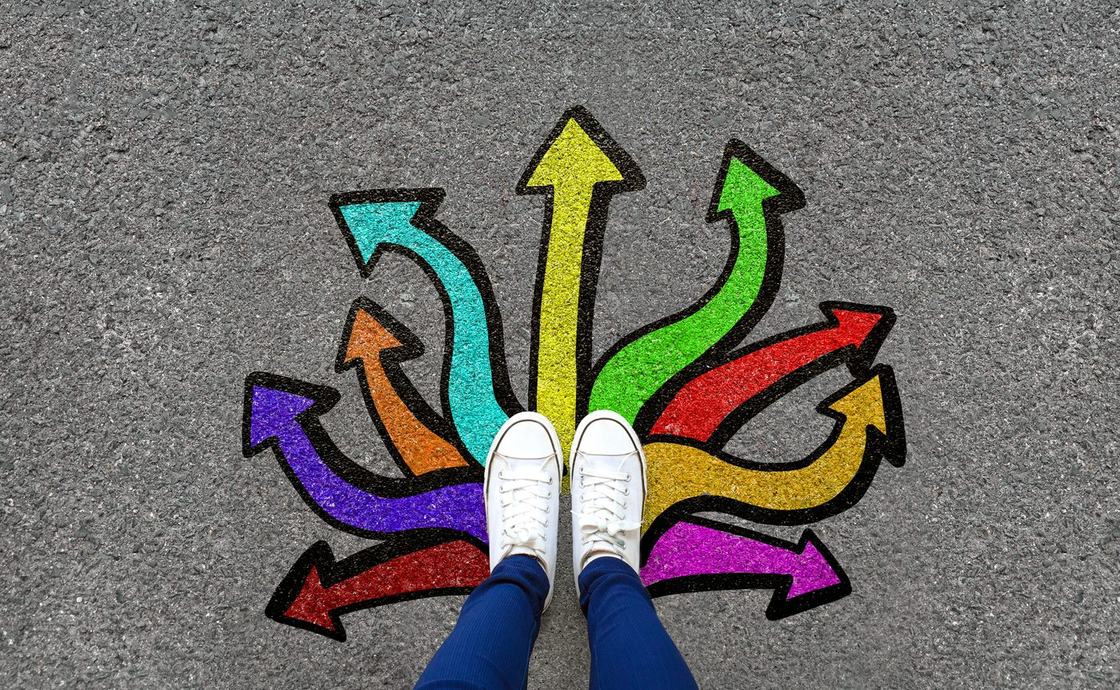 Feet at the centre of colourful arrows pointing in every direction